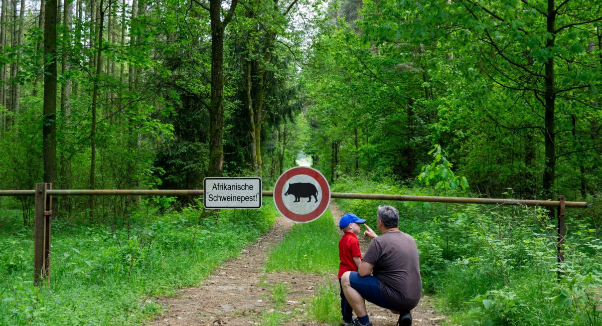 Vater und Sohn stehen vor dem ASP-Schild